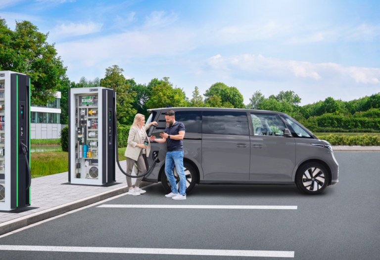 Parking lot with a DC charging station. An electric vehicle is connected to the DC charging station and is charging.