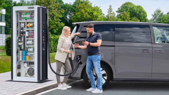Parking lot with a DC charging station. An electric vehicle is connected to the DC charging station and is charging.
