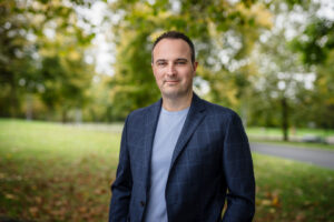 Mann im Anzug steht in der Landschaft